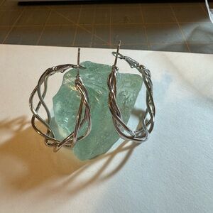 Pair of silver colored metal twisted hoop earrings
NWOT. Shiny cute earrings.